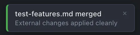 Toast notification showing 'test-features.md merged — External changes applied cleanly'